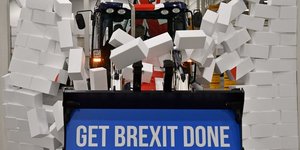 En pleine campagne pour les législatives, Boris Johnson fonce, au volant d'un bulldozer aux couleurs britanniques, vers un mur en briques de polystyrène sur lequel on peut lire le mot "impasse".