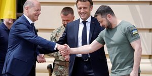Le president ukrainien volodimir zelensky serre la main du chancelier allemand olaf scholz a cote du president francais emmanuel macron