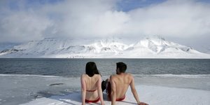 Les activistes du climat Lesley Butler et Rob Bell prennent un bain de soleil sur la banquise arctique norvgienne le 25 avril 2007