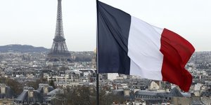 Photo d'archives montrant un drapeau francais flottant pres de la tour eiffel a paris