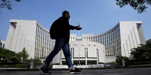 Un homme passe devant le siege de la banque populaire de chine