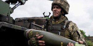 Un militaire ukrainien porte un obus pour un obusier automoteur caesar avant de tirer en direction des troupes russes pres d& 39 avdiivka