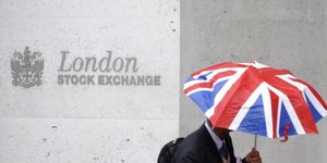 Un travailleur tient en parapluie aux couleurs du Royaume-Uni devant le London Stock Exchange en octobre 2008 Bourse, marchEs financiers